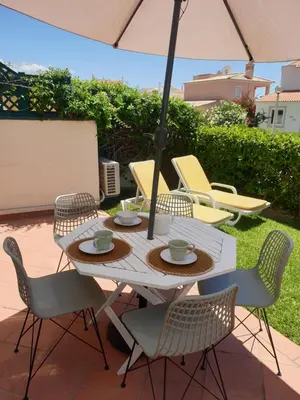 a table with chairs and an umbrella on a patio at T2 Apartment Old Village Vilamoura in Vilamoura