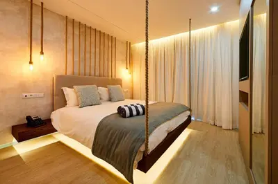 a bedroom with a hanging bed and a television at Areias Senses in Albufeira