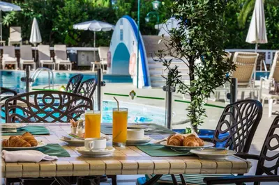 a table with croissants and drinks next to a pool at Four Seasons Country Club in Quinta do Lago