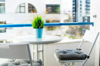 a table and two chairs with a plant on a balcony at Apartamento Mar in Quarteira