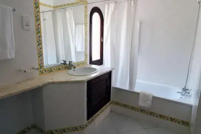 a bathroom with a sink and a mirror and a tub at Vilamouratenis 'Blue' by SAPvillas in Vilamoura