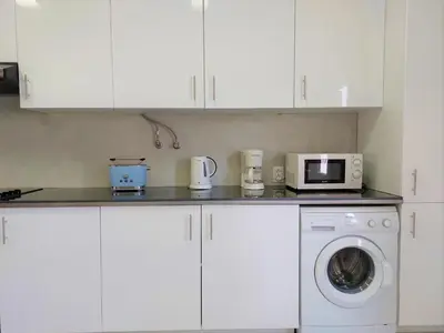 a kitchen with a washing machine and a microwave at Vilamouratenis 'Blue' by SAPvillas in Vilamoura