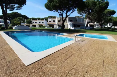 a swimming pool in front of a house at Vilamouratenis 'Blue' by SAPvillas in Vilamoura