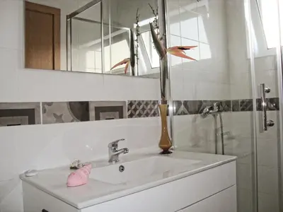 a bathroom with a sink and a mirror and a shower at Vila Algarvia Boutique & Suites in Albufeira