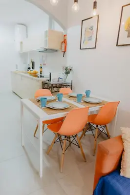 a dining room table with orange chairs in a kitchen at Home Santa Clara in Albufeira
