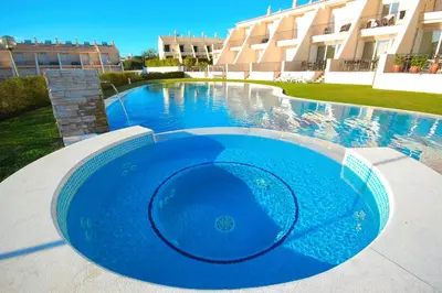 a large blue swimming pool in front of a building at House F São Rafael Beach - Free Wifi & Airco, NETFLIX ready - 300m from the beach in Albufeira