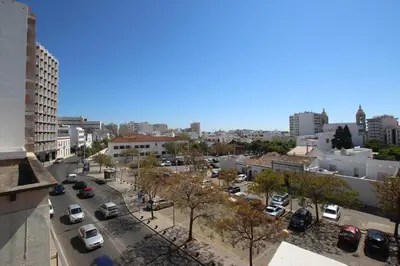 a city street with cars parked in a parking lot at Carmo Twenties Apartment in Faro