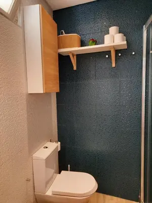 a bathroom with a toilet and a black wall at Carmo Twenties Apartment in Faro