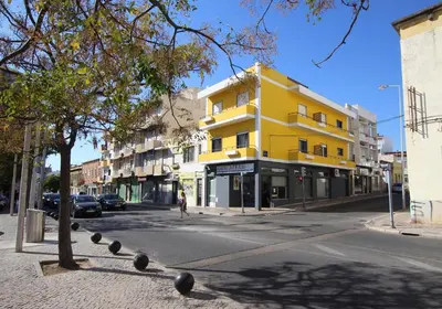 a yellow building on the side of a street at Carmo Twenties Apartment in Faro