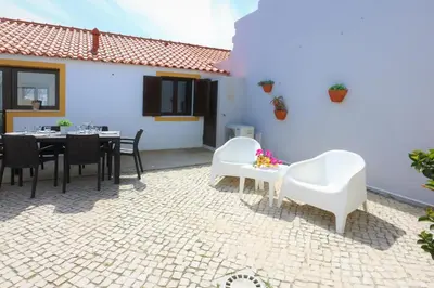 a patio with a table and chairs and a building at Vila - Mar - Private outdoor Jacuzzi - wifi & airco - by bedzy in Albufeira