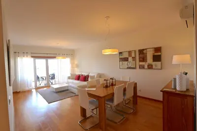 a dining room and living room with a table and chairs at Golf Mar Village - Clever Details in Vilamoura