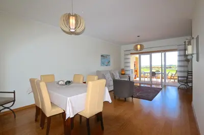 a dining room and living room with a table and chairs at Golf Mar Village - Clever Details in Vilamoura