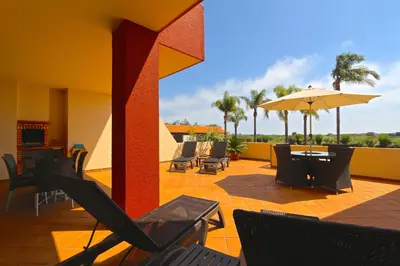 a patio with chairs and a table and an umbrella at Golf Mar Village - Clever Details in Vilamoura