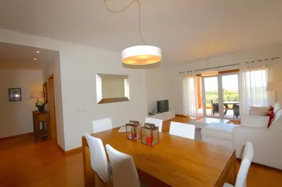 a dining room and living room with a table and chairs at Golf Mar Village - Clever Details in Vilamoura