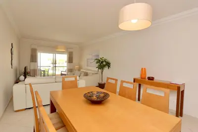 a living room with a table and a couch at Praia Village 104 - Clever Details in Vilamoura