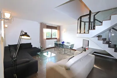 a living room with a couch and a staircase at Monte Laguna - Clever Details in Vilamoura