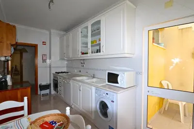 a kitchen with a washing machine and a microwave at Falésia Marina - Clever Details in Vilamoura