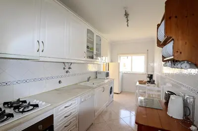a kitchen with white cabinets and a stove top oven at Falésia Marina - Clever Details in Vilamoura