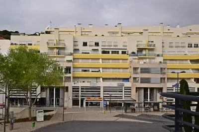 a large building with yellow balconies and a parking lot at Old town in Albufeira