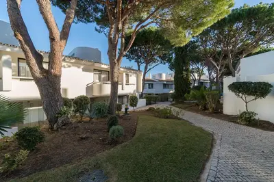 a garden in front of a house with trees at BmyGuest - Quinta do Lago Mezzanine Apartment in Almancil