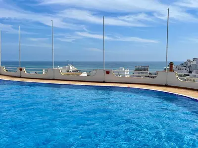 a swimming pool with the ocean in the background at Ocean Balcony apartment terrace sea view and pool in Albufeira