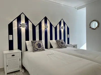 two beds in a bedroom with black and white stripes at Ocean Balcony apartment terrace sea view and pool in Albufeira