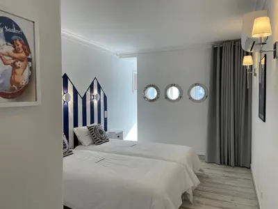 a bedroom with two beds and two mirrors on the wall at Ocean Balcony apartment terrace sea view and pool in Albufeira