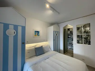 a bedroom with a large white bed with blue accents at Ocean Balcony apartment terrace sea view and pool in Albufeira