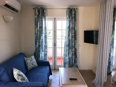 a living room with a blue couch and a sliding glass door at Old Village in Vilamoura