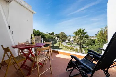 a patio with a table and chairs on a balcony at BmyGuest - Quinta do Lago Terrace Apartment II in Quinta do Lago