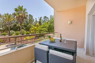 a table with a bottle of wine on a balcony at Apartamento em Quinta da Barracuda in Albufeira