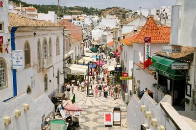 a group of people walking down a city street at Apartamento em Quinta da Barracuda in Albufeira