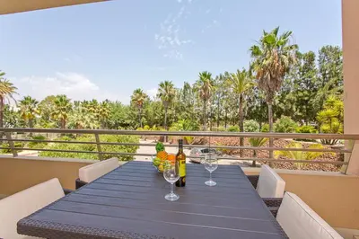 a table with wine bottles and glasses on a balcony at Apartamento em Quinta da Barracuda in Albufeira