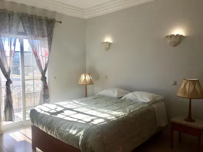 a bedroom with a bed with two lamps and a window at Casa das Figuras in Faro