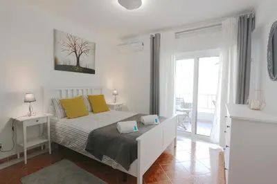 a white bedroom with a bed with yellow pillows at Pinhal do Golf - Clever Details in Vilamoura