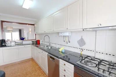 a kitchen with white cabinets and a sink at Pinhal do Golf - Clever Details in Vilamoura