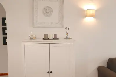 a white cabinet in a living room with a lamp at Pinhal do Golf - Clever Details in Vilamoura