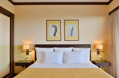 a bedroom with a bed with two pictures on the wall at Pestana Vila Sol - Vilamoura Premium Golf Resort in Vilamoura