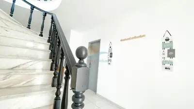a staircase with black railings in a white room at Vila Ricardo by Sunny Deluxe in Albufeira