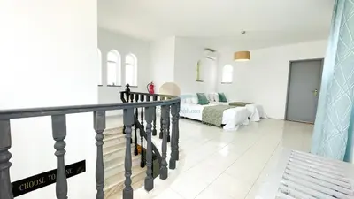 a white living room with a bed and a staircase at Vila Ricardo by Sunny Deluxe in Albufeira