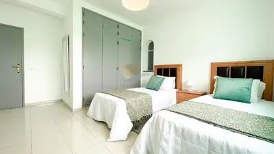 two beds in a room with white walls at Vila Ricardo by Sunny Deluxe in Albufeira