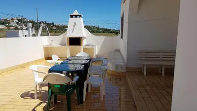 a balcony with a table and chairs and a lighthouse at Vila Ricardo by Sunny Deluxe in Albufeira