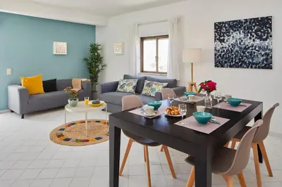 a living room with a table and a couch at Casas Barulho Apartments Old Town in Albufeira