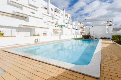 a swimming pool in front of a white building at Casas Barulho Apartments Old Town in Albufeira