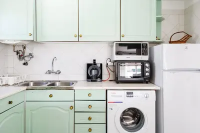 a kitchen with a washer and a microwave at Casas Barulho Apartments Old Town in Albufeira
