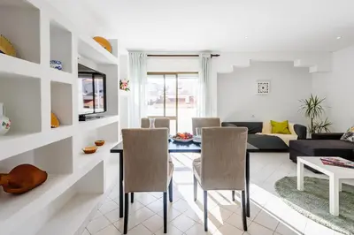 a living room with a table and chairs at Casas Barulho Apartments Old Town in Albufeira