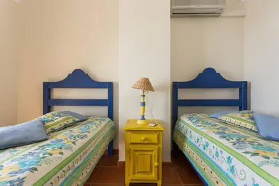 a bedroom with two beds and a table with a lamp at Marina de Vilamoura Apart in Vilamoura