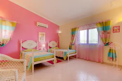 a bedroom with two beds and a pink wall at Villas2go2 V5 Vilamoura XXI in Vilamoura