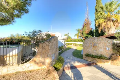 a stone wall with a gate and a path at Villas2go2 V5 Vilamoura XXI in Vilamoura