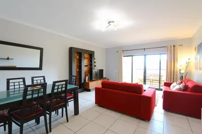 a living room with a red couch and a table at Terraços de Vilamoura 55- Clever Details in Vilamoura